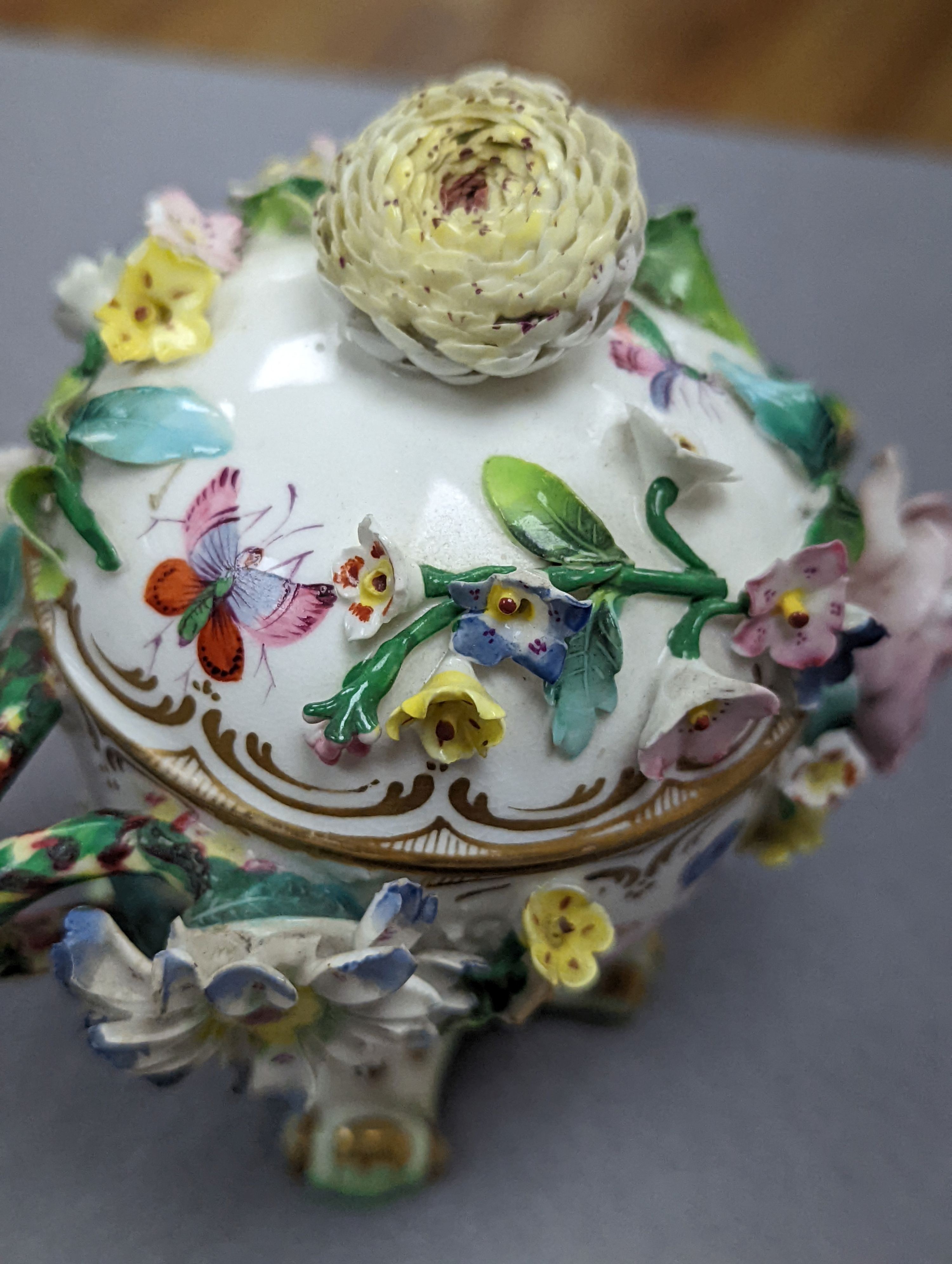 An 18th century Mennecy porcelain cup and cover, a Meissen style cup and cover, an English porcelain floral encrusted double inkwell and cover and a similar jar and cover